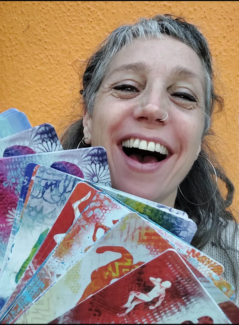 Émilie Buscema souriante, tenant un éventail de cartes MUEVO